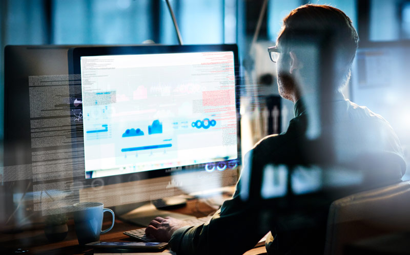 An image of a male computer programmer working on new code.